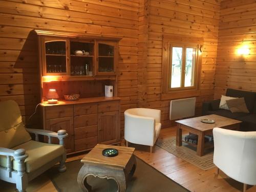 - un salon dans une cabane en rondins dans l'établissement Chalet en bois sur grand parc arboré tout proche de l océan, à Vendays-Montalivet