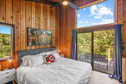 a bedroom with a bed and a large window at Glenwood Springs Mountain Getaway with Hot Tub and Riverfront in Glenwood Springs