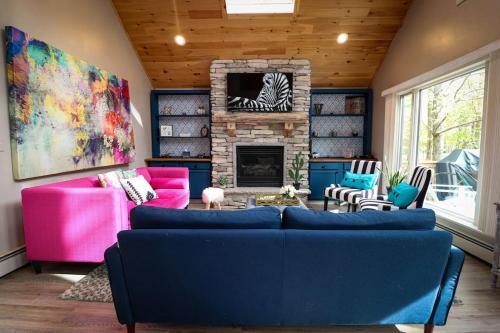 a living room with a couch and a fireplace at Villa MiaNova A Modern Hideout in the Woods in Lake Ariel
