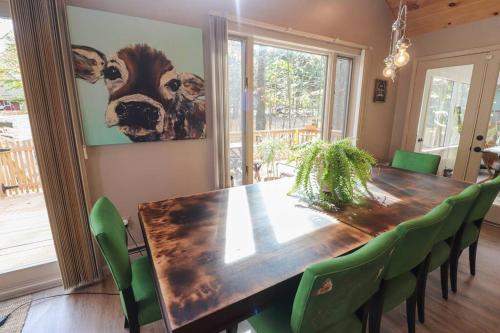 a dining room with a wooden table and green chairs at Villa MiaNova A Modern Hideout in the Woods in Lake Ariel