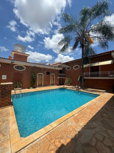 a large swimming pool in front of a building at Pousada Agua Quente in Olímpia