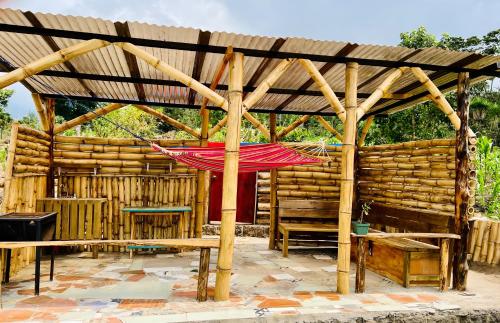 a wooden pavilion with a red hammock hanging from it at Luxe A-Frame on Lake Atitlán in Santiago Atitlán