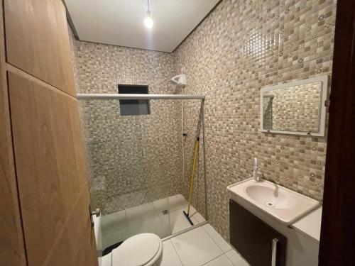 a bathroom with a toilet and a sink at Casa com piscina e ar condicionado in Seabra