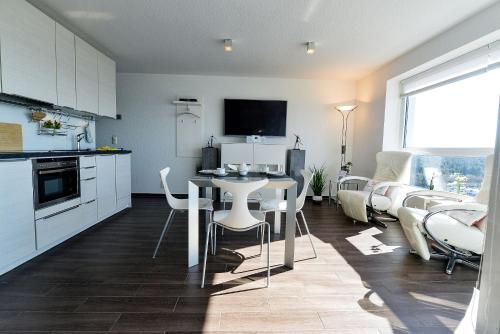 a kitchen and living room with a table and chairs at Haus Frische Brise 1507 in Cuxhaven