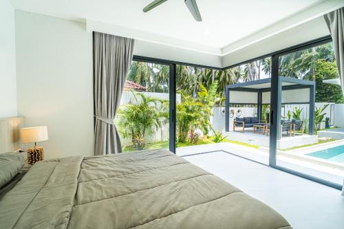 a bedroom with a large bed and a pool at Villa Petra in Nathon Bay