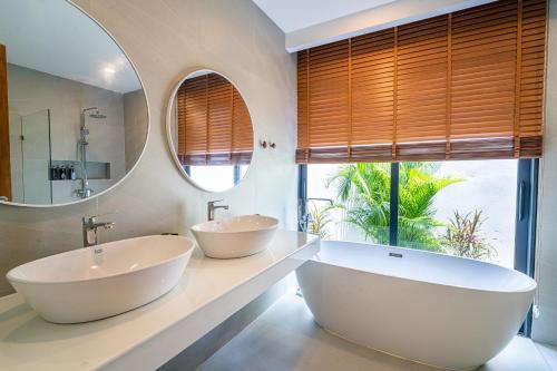 two sinks in a bathroom with a large window at Villa Petra in Nathon Bay