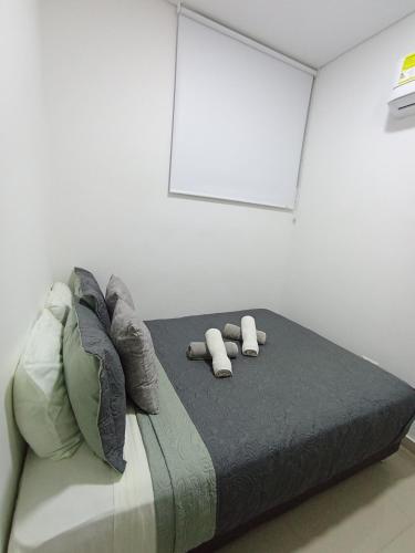 a bedroom with a bed with two pillows on it at ESPECTACULAR APARTAMENTO EN SAMARIA CLUB DE PLAYA smr in Gaira