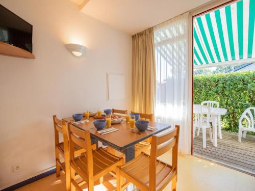 une salle à manger avec une table et des chaises et une grande fenêtre dans l'établissement Apartment in Saint-Jean-Pied-de-Port with Balcony, à Saint-Jean-Pied-de-Port
