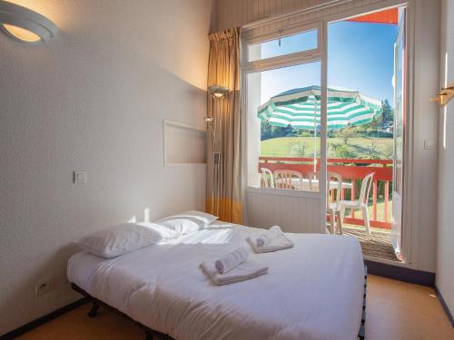 un lit dans une chambre avec une grande fenêtre dans l'établissement Appartement 3 Pièces 5 Personnes 1 bébé, à Saint-Jean-Pied-de-Port