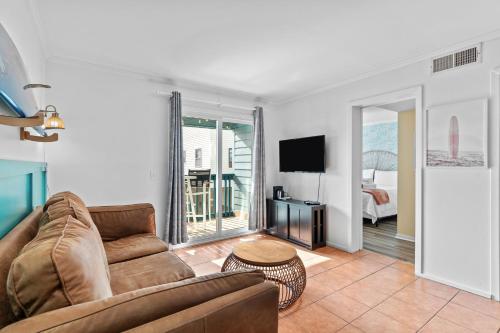 a living room with a couch and a television at Hang Ten Hideaway, pool, Condo, Parking - 6 person max occupancy in Carolina Beach