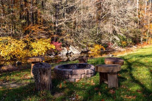 a garden with a fire pit and two logs at Heated Indoor Private Pool Stream Front Game Room in Cresco