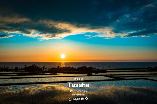 a sunset over the ocean with the sun in the sky at SADO Cottage SUNSETHILLS in Sado