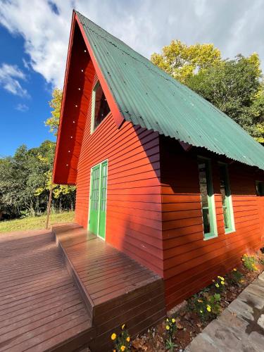a small red house with a wooden deck at Chalé Plátano in Garibaldi