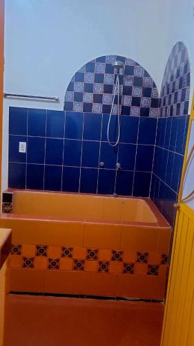 a bathroom with a tub with blue tiles at Casita Paraiso Escondido in La Peñita de Jaltemba