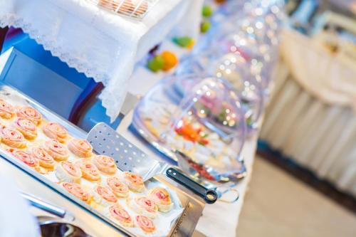 a table with a tray of donuts and other food at Hotel Ottaviano in Świnoujście
