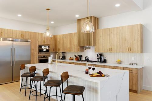 a kitchen with a large white island with bar stools at LUXE - Nouveau - Sparkling Pool - Walk to Old Town in Scottsdale