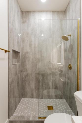 a shower with a glass door in a bathroom at LUXE - Nouveau - Sparkling Pool - Walk to Old Town in Scottsdale