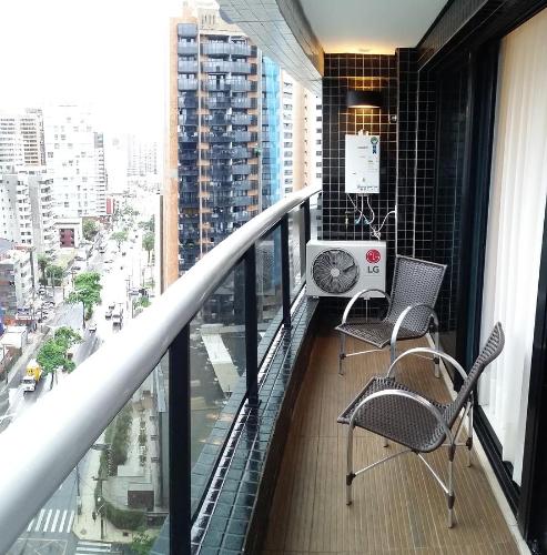 a balcony of a building with two chairs and a desk at Landscape Apartment TC1502 in Fortaleza
