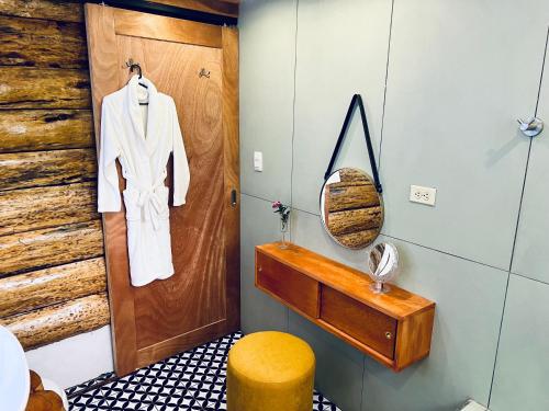 a bathroom with a wooden door and a yellow stool at Luxe A-Frame on Lake Atitlán in Santiago Atitlán