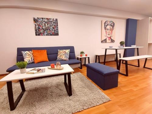 Una sala de estar con un sofá azul y una mesa. en Misti Suite, en Arequipa