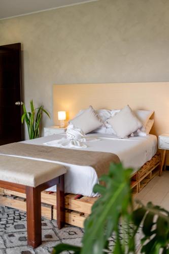a bedroom with a large bed and a bench at House of Turri Suite Views Terrace & Jacuzzi in Verbena Norte