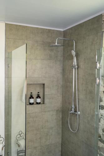 a bathroom with a shower with two bottles on a shelf at House of Turri Suite Views Terrace & Jacuzzi in Verbena Norte