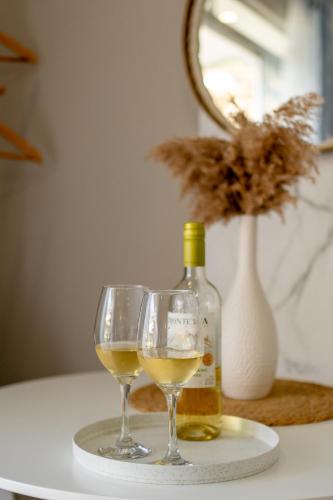 two glasses of white wine and a bottle on a table at House of Turri Suite Views Terrace & Jacuzzi in Verbena Norte