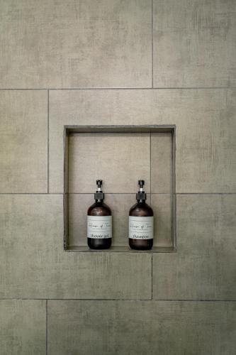 two bottles on a shelf on a wall at House of Turri Suite Views Terrace & Jacuzzi in Verbena Norte