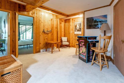 a living room with wood paneling and a table and chairs at Whispering Pines Chalet Game Room Fire Pit in Pocono Pines