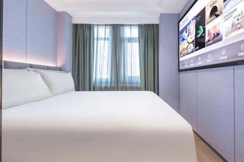 a bedroom with a white bed and a tv at Atour X Hotel Beijing CBD International Trade Bridge in Beijing