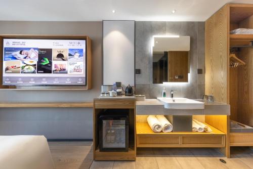a bathroom with a sink and a tv on the wall at Atour X Hotel Beijing CBD International Trade Bridge in Beijing