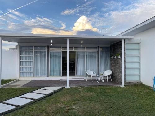 a house with two chairs on a patio at Summer House in Chame
