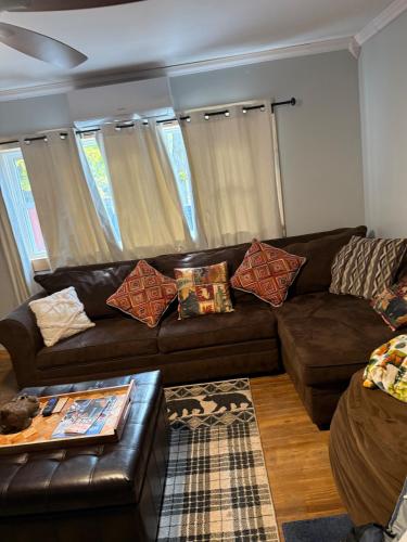 a living room with a brown leather couch at The Cabins at Walnut Grove-minutes from Hunter and Windham in Ashland