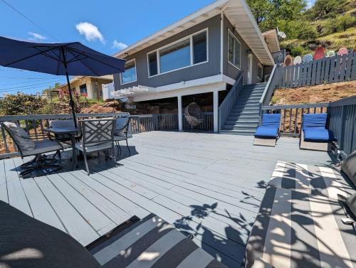 WaianaeにあるPanoramic Viewhouse Only 2-min Drive To Beach!の家の上に椅子とパラソル付きのパティオ