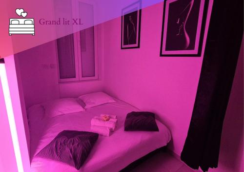 une chambre rose avec un lit et une boîte rose dans l'établissement Le Cocon des Amoureux, à Villeurbanne