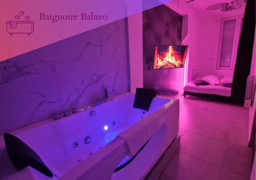 d'une salle de bains pourpre avec une baignoire et une cheminée. dans l'établissement Le Cocon des Amoureux, à Villeurbanne