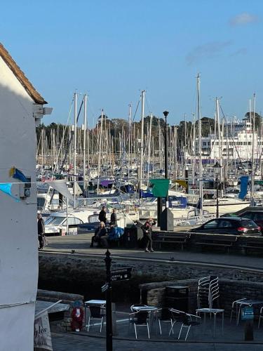 a marina with a bunch ofocked boats and people sitting at LB Newgate in Lymington