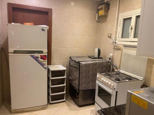 a small kitchen with a refrigerator and a stove at شقة فخمة للايجار in Cairo