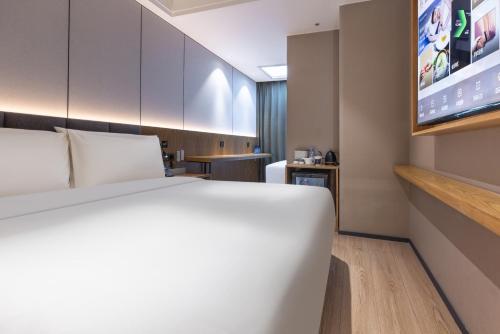 a hotel room with a bed and a flat screen tv at Atour X Hotel Beijing CBD International Trade Bridge in Beijing