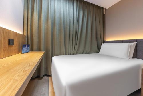 a bedroom with a large white bed and a desk at Atour X Hotel Beijing CBD International Trade Bridge in Beijing