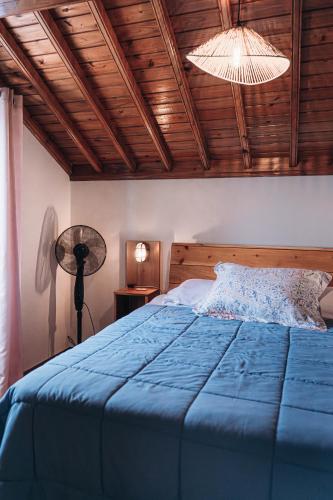 a bedroom with a blue bed with a wooden ceiling at Oceanview Sunset Retreat in Pilar