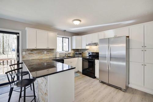 a kitchen with white cabinets and a stainless steel refrigerator at Blue Wolf Retreat Pool Table Cozy BBQ in Albrightsville