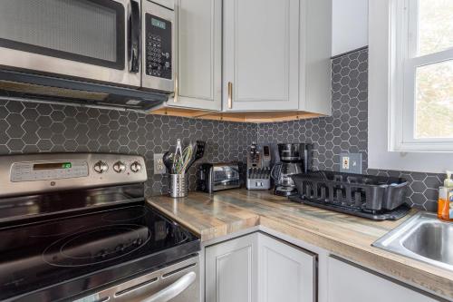 a kitchen with white cabinets and a stainless steel appliance at Tranquil Shores Waterfront Fire Pit Hammock in Tobyhanna