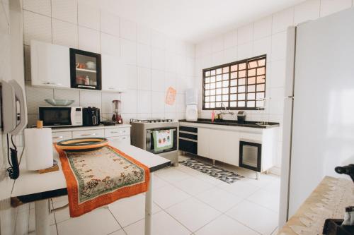 a kitchen with white appliances and a table in it at Villa Rio in Brotas