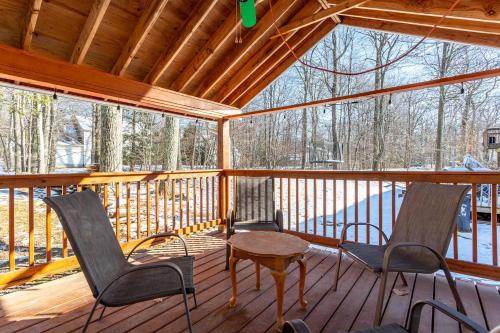 a screened porch with chairs and a table on it at The Woodland Escape Pool Table Fire Pit 4 BD in Tobyhanna