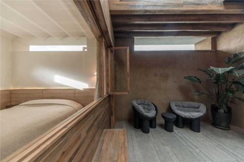 a bedroom with a bed and two stools at Shaxi Ancient Town Shiran Mountain Homestay in Jianchuan