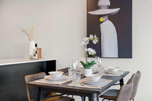 a dining room table with chairs and a hat on the wall at Modern Penthouse 3 Bed & 2 Bath-Skytower View-Pool in Auckland