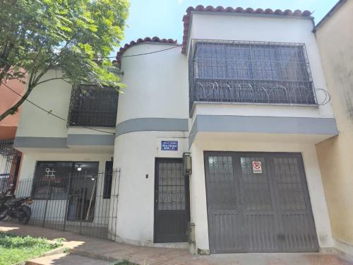 a white building with two doors and a balcony at Donde Emilio in Pereira