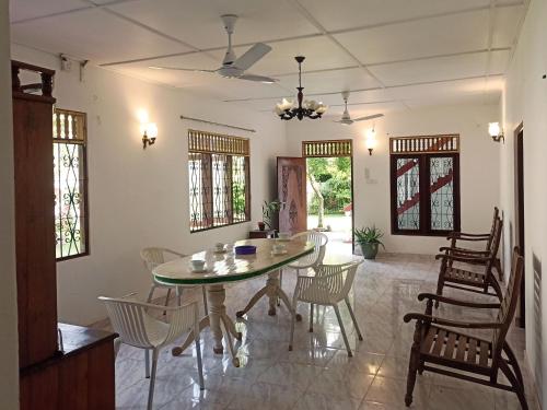 ein Esszimmer mit einem Glastisch und Stühlen in der Unterkunft Neem Trees Unawatuna in Unawatuna