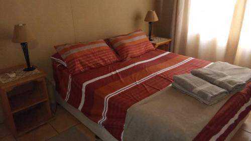 a bed in a bedroom with two pillows on it at Rhulani Treetop Cottage in Marloth Park